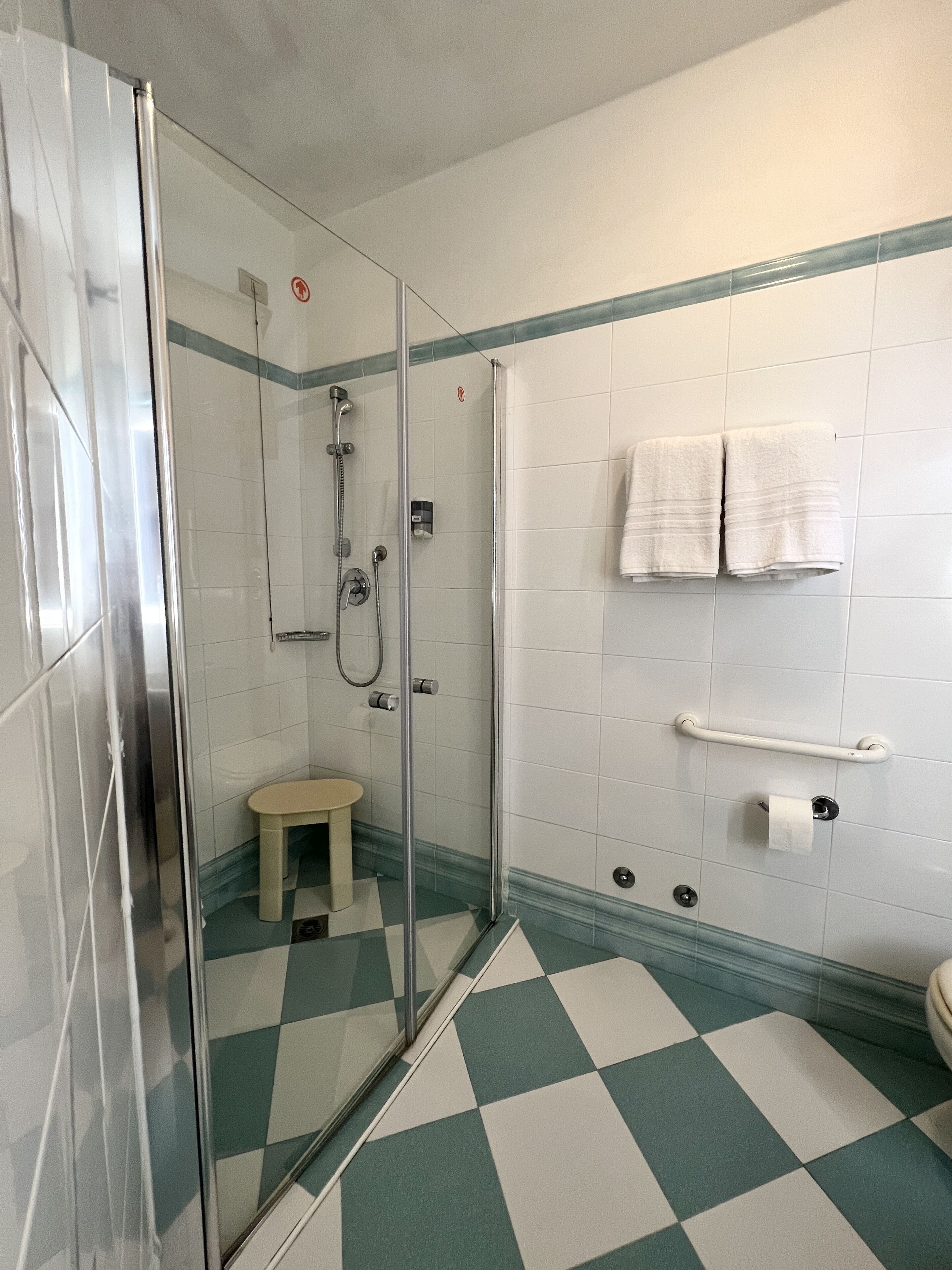 Een badkamer met een douchecabine, toilet en wastafel.