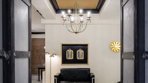 A modern interior with a black leather sofa, a chandelier, and a framed artwork on the wall. - Hotel YIT Casablanca (Granada)