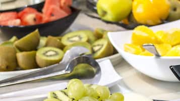 Een ontbijtbuffet met diverse soorten fruit en drankjes.