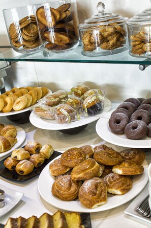 Un bufé con diversos pasteles y productos de repostería.