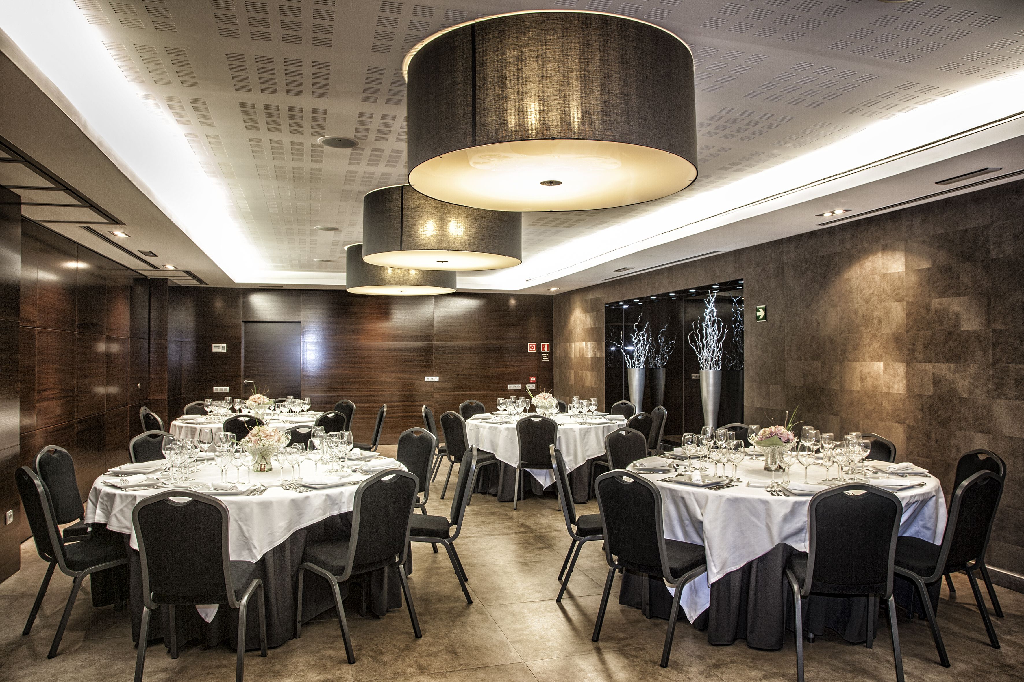 A banquet hall with round tables set for dining, equipped with chairs and table settings.