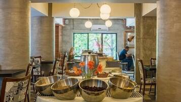 A dining area with a buffet setup, including metal bowls and a central serving station.