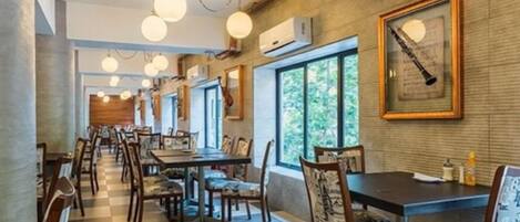 Un restaurante con suelo de cuadros, mesas y sillas de madera.