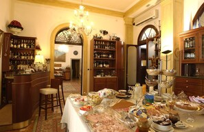 Un élégant espace de restauration d’hôtel offrant un choix varié de plats et de boissons, notamment un buffet et un bar proposant une vaste sélection de vins.