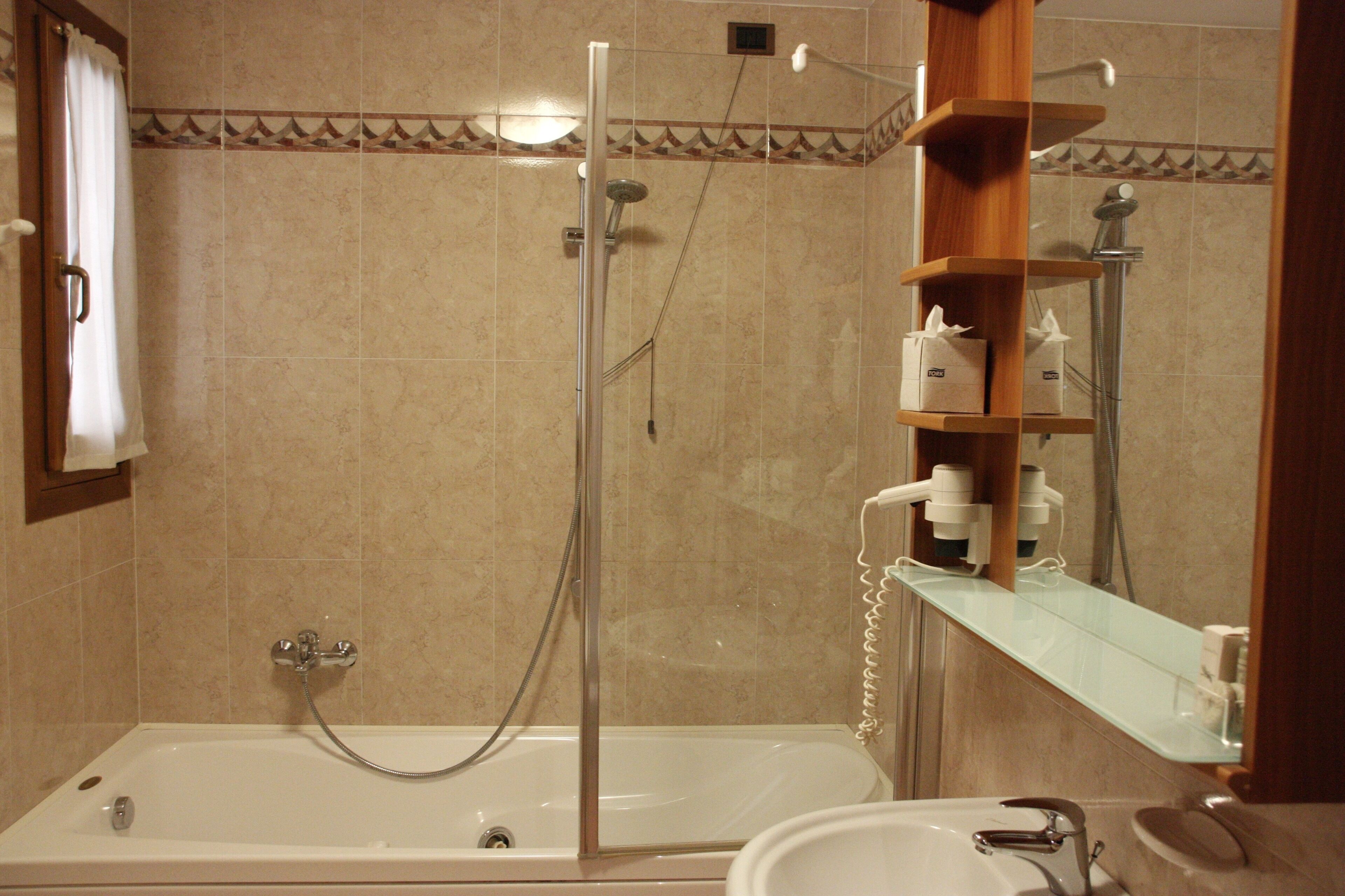 Une salle de bain avec une baignoire, une douche et un lavabo.