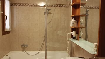 Une salle de bain avec une baignoire, une douche et un lavabo.