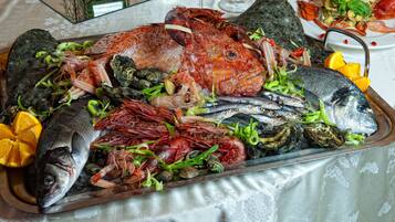 A seafood platter with various types of fish and shellfish, including a whole fish, shrimp, and mussels, arranged on a tray.