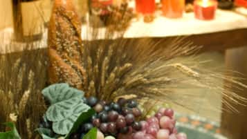 A table with various bottles of wine and candles, surrounded by decorative elements like grapes and leaves.
