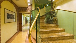 A marble staircase with glass railings and a decorative sculpture at the top. - AS Hotel Monza (Monza)