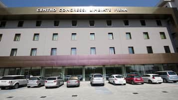 A hotel named Centro Congress with a modern facade and a parking lot with several cars.