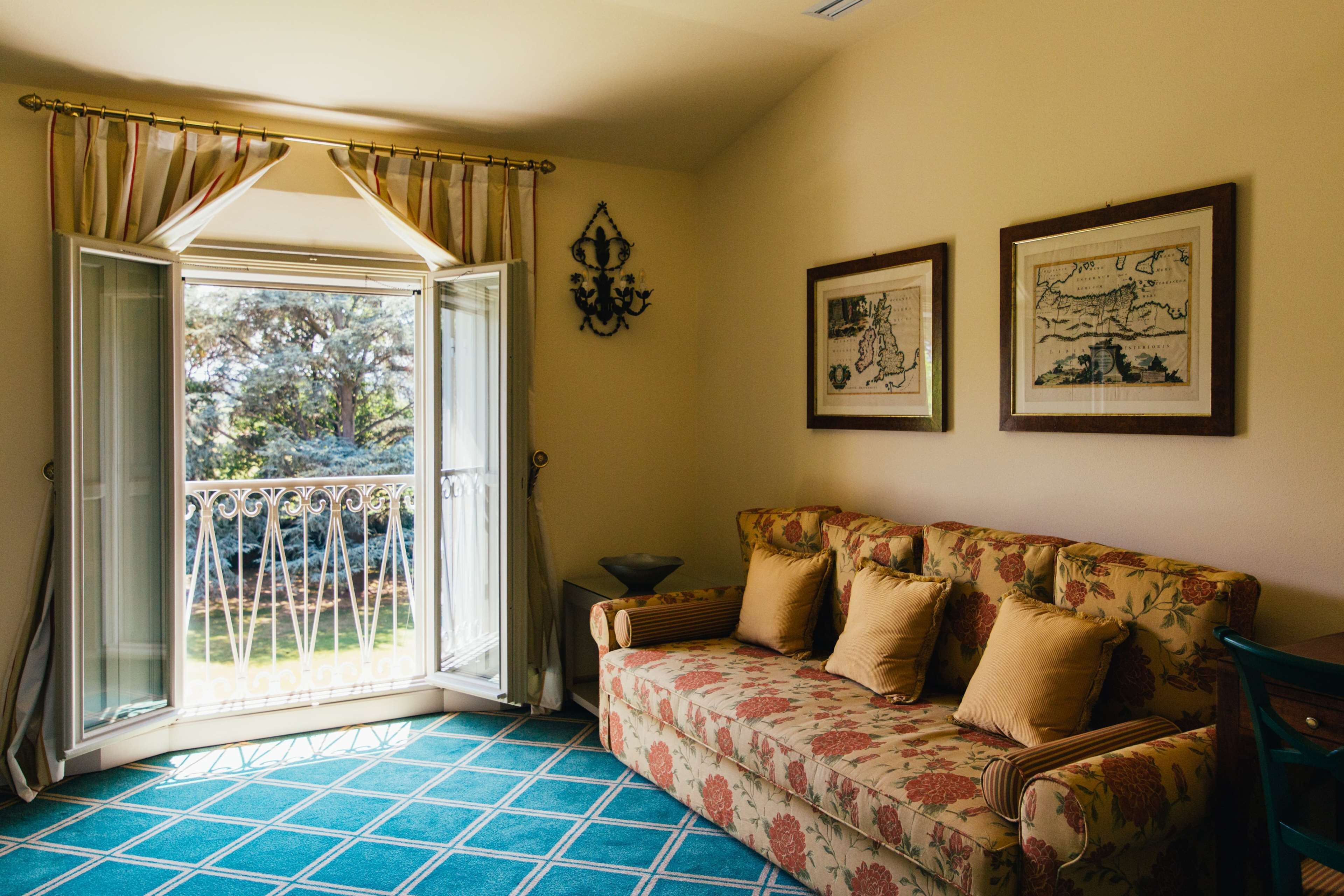 A room with a sofa, a table, and a window with curtains.