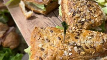 Ein Holzbrett mit mehreren Sandwiches, jedes mit einem Zahnstocher.