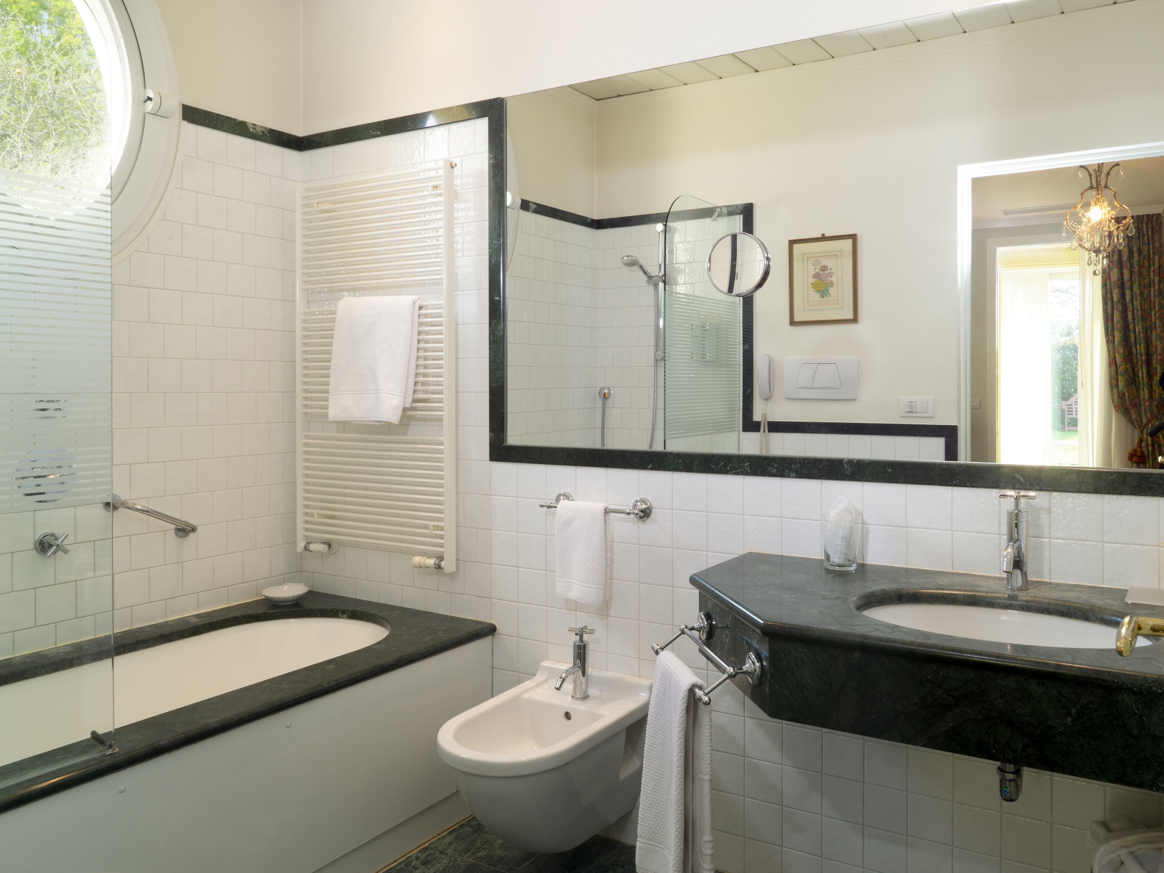 A bathroom with a bathtub, a bidet, and two sinks.