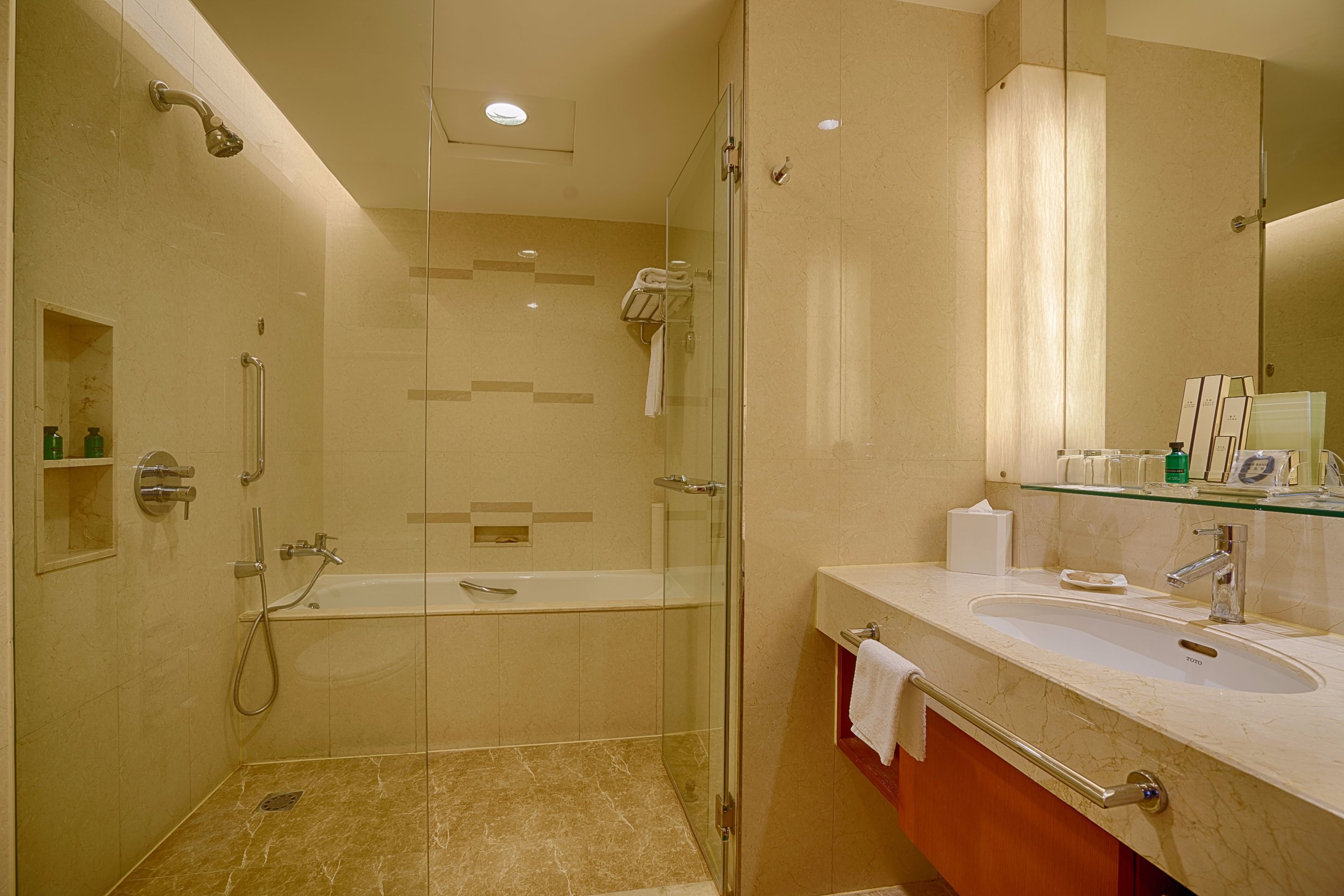 Un baño moderno con ducha envuelta en vidrio, una bañera independiente y un tocador con lavabo.