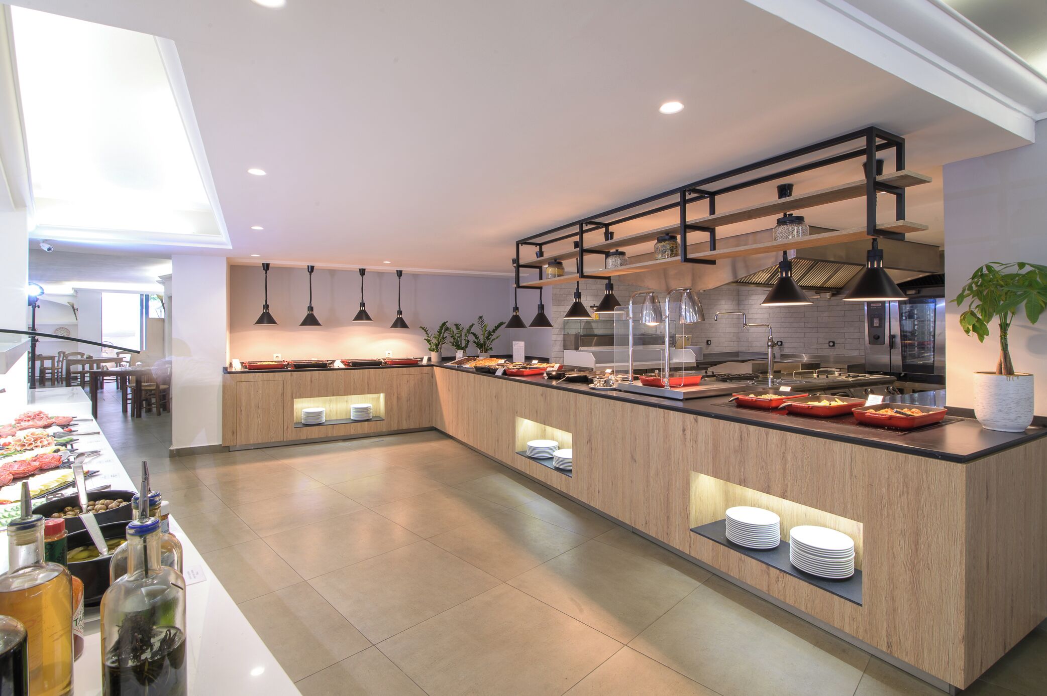 Una cucina moderna con isola centrale, illuminazione a sospensione e vista sull'area pranzo.