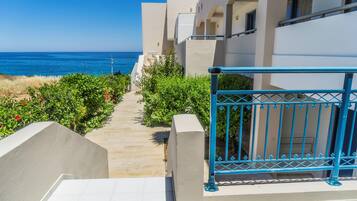 A pathway leading to a building with a view of the sea.