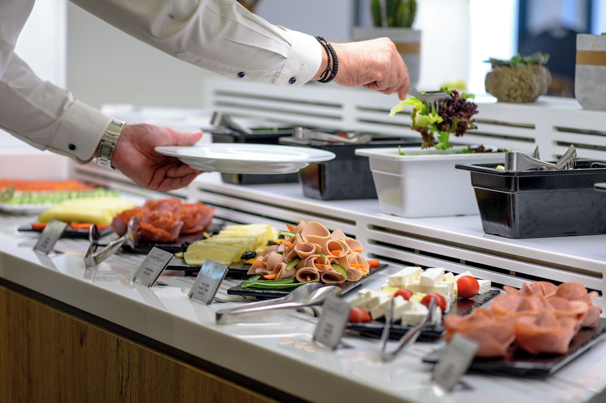 Een buffet met verschillende soorten eten, zoals vlees, kazen en groenten.