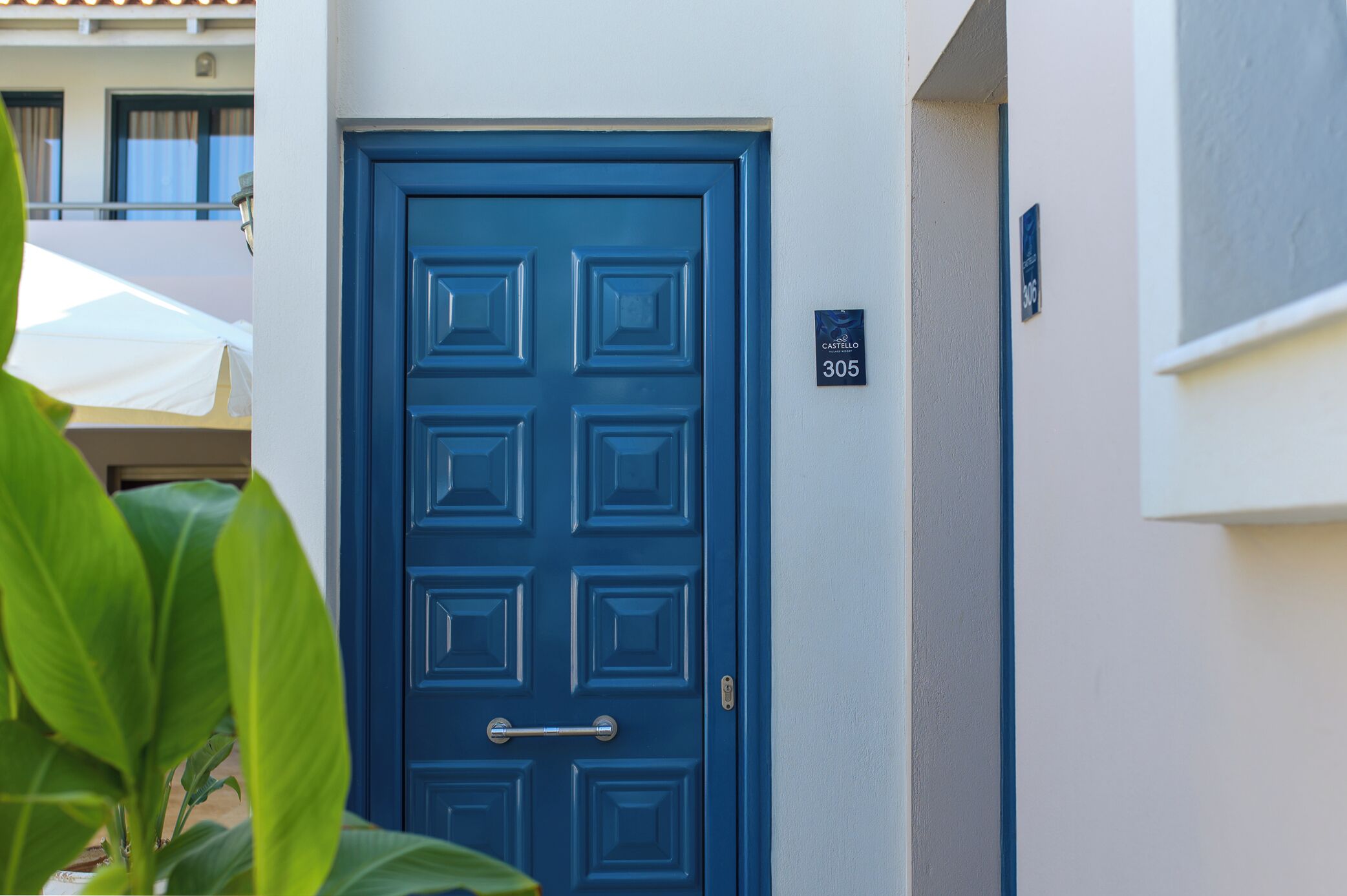 A blue door with a handle and a number plate indicating room 305.