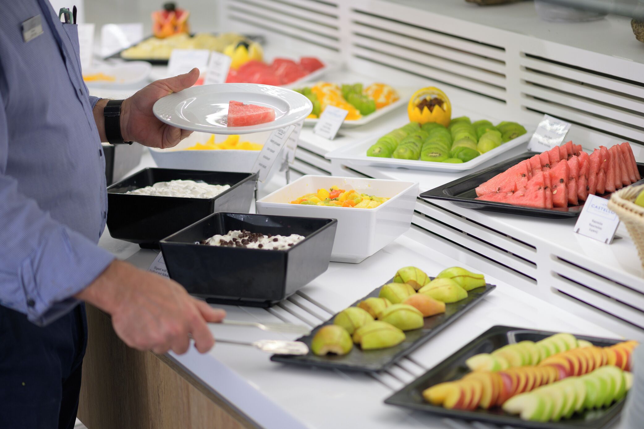 Un bufé con diversas frutas y postres.