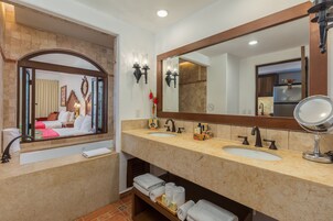 Un baño con dos lavamanos, un espejo grande y una bañera.