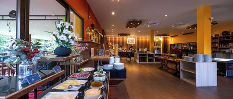 A hotel lobby with a buffet area, a reception desk, and a view of the outdoors.