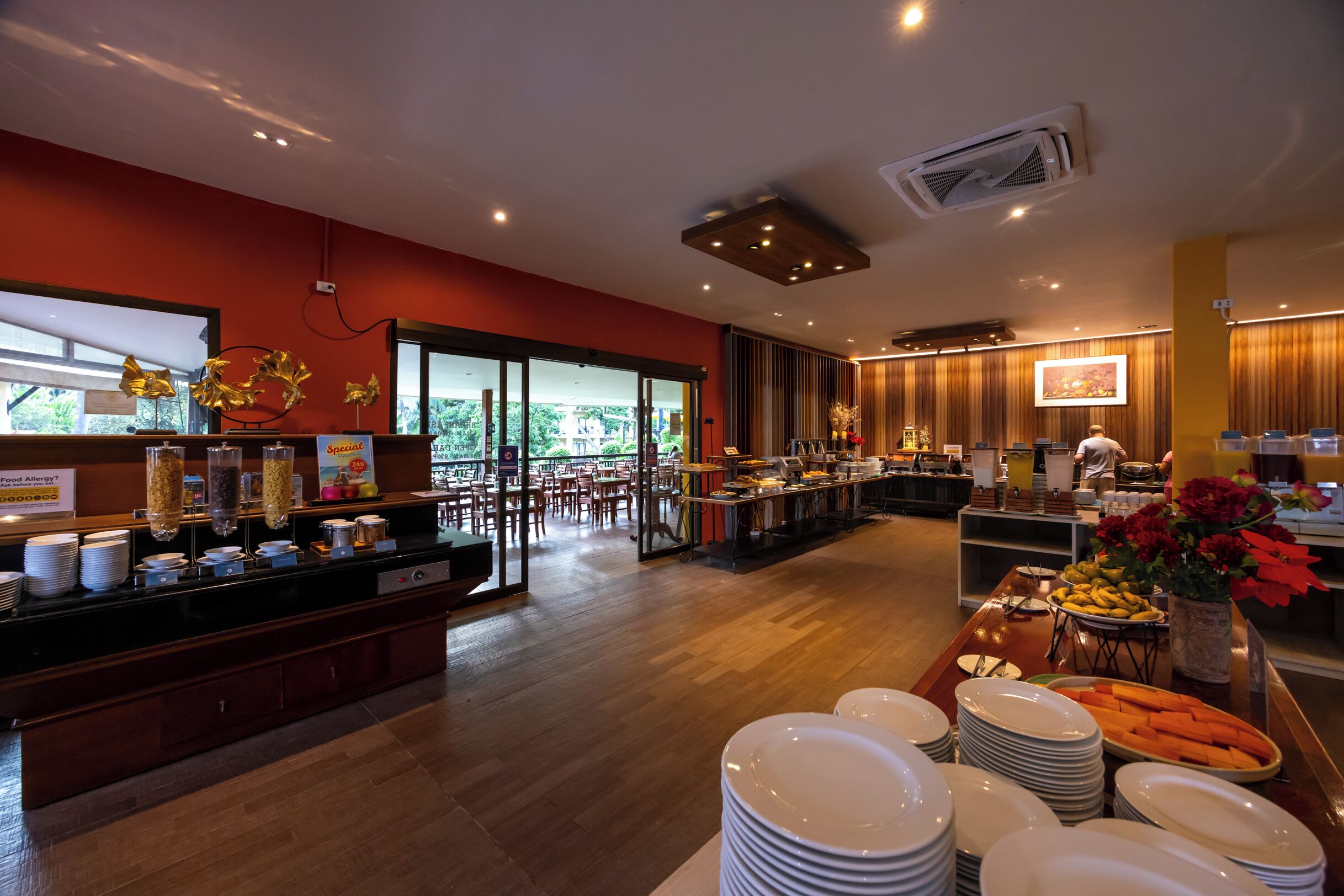 Un buffet proposant une variété de plats, un espace pour s’asseoir et une cuisine en arrière-plan.