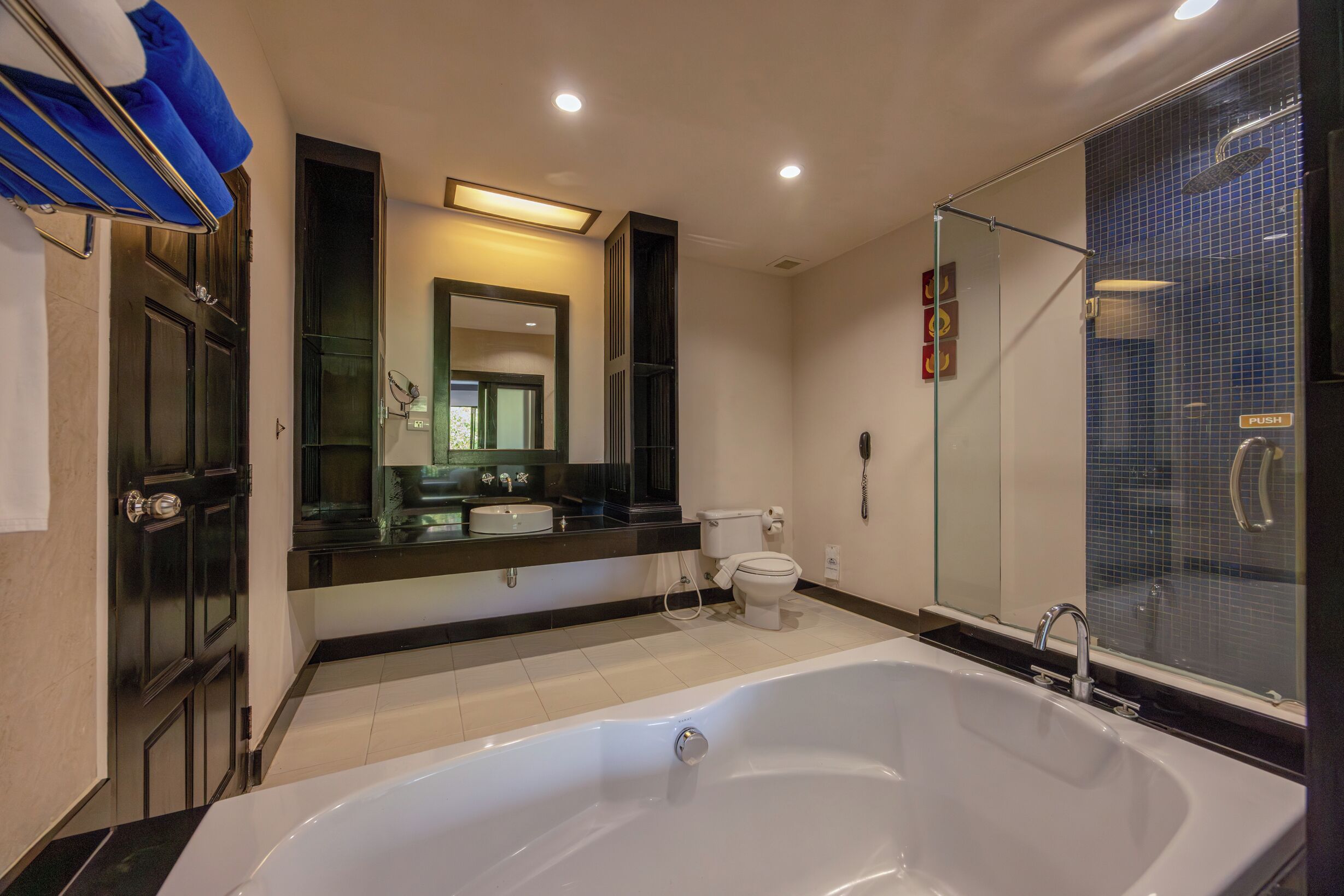 A bathroom with a large bathtub, a glass shower enclosure, a toilet, and a sink.