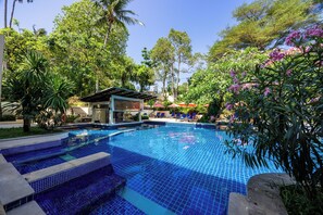 A swimming pool with blue tiles, surrounded by greenery and a small structure with a roof. - Horizon Karon Beach Resort & Spa (Karon)