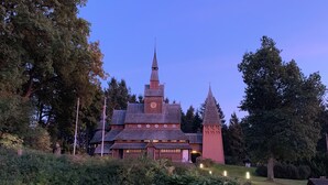 Ein traditionelles Holzgebäude mit einem steilen Satteldach und einem markanten Turm.