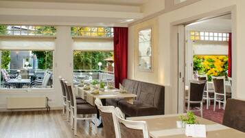 A dining area with a long table, multiple chairs, and a view of the outdoors.