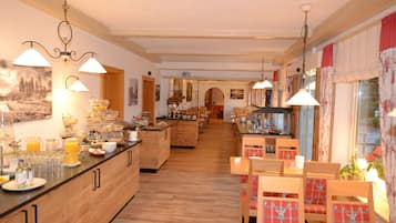 A spacious kitchen with wooden cabinets, a breakfast bar, and a dining area with wooden tables and chairs.