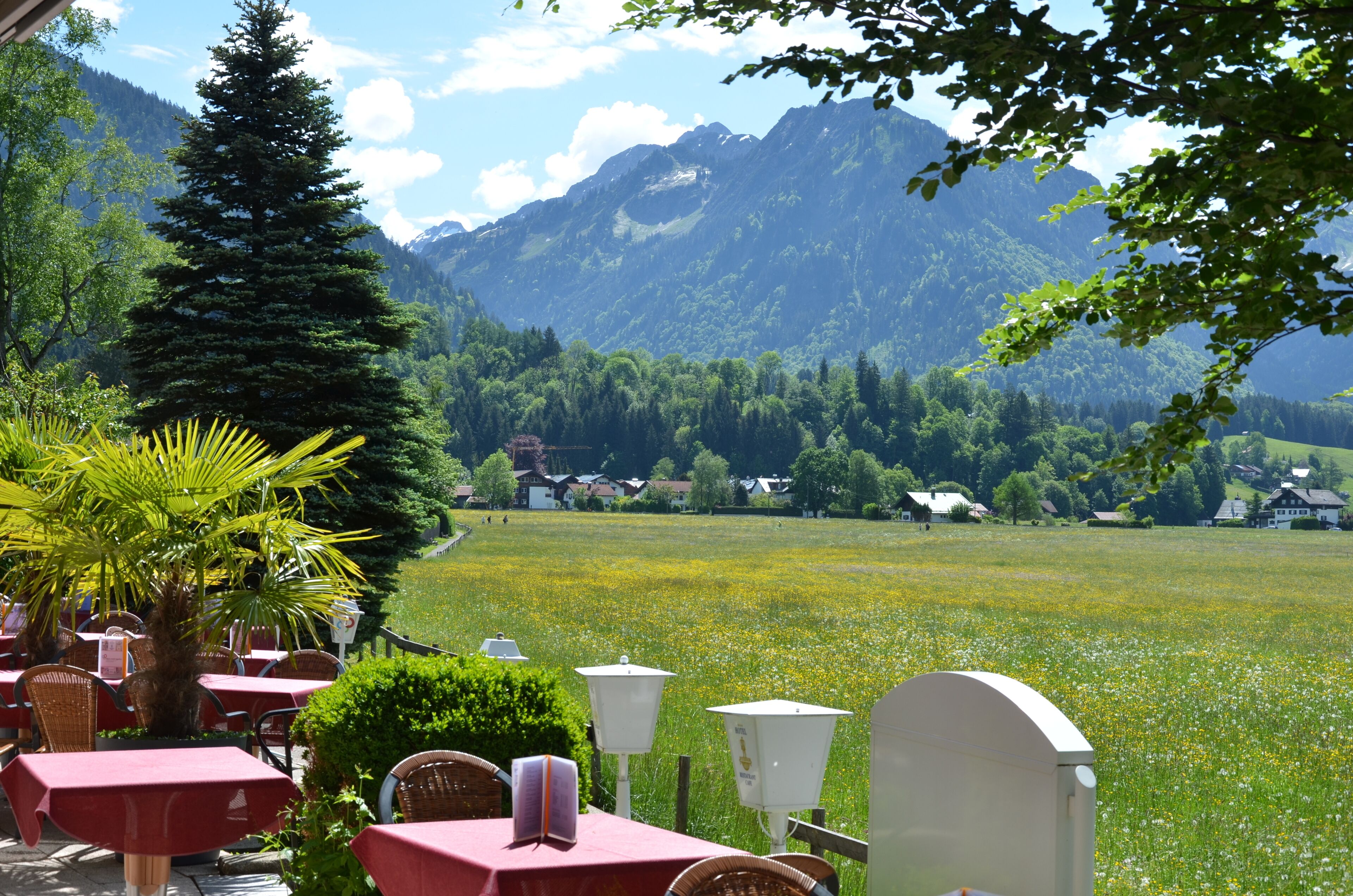 A restaurant with outdoor seating overlooking a mountain landscape.