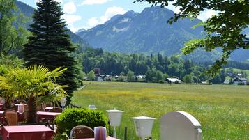 A restaurant with outdoor seating overlooking a mountain landscape.