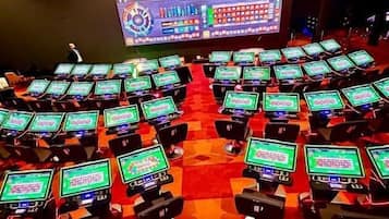 Un salón de conferencias con varias filas de mesas, cada una con un monitor de ordenador.