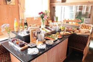 Buffet de café da manhã com diversos alimentos e bebidas.
