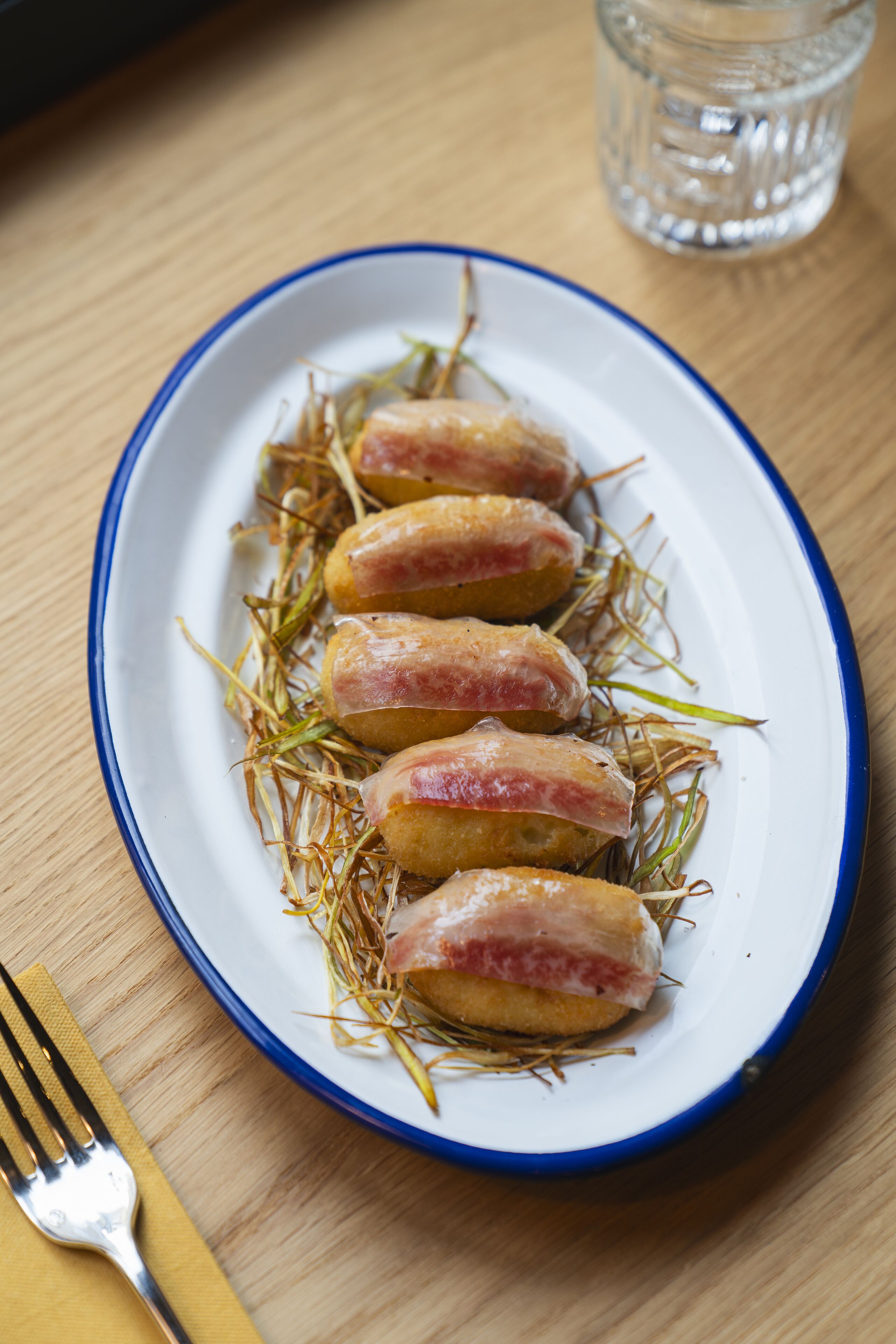 A plate of food with a blue rim on a wooden table.
