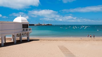 Playa en los alrededores, playa de arena blanca y toallas de playa 