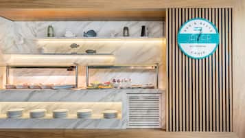Una barra de desayuno con encimeras de mármol, un reloj y un diseño de paneles de madera.