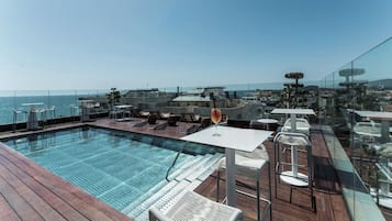 Una piscina al aire libre de temporada, sillones reclinables de piscina