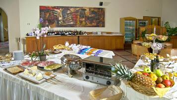 Montaje de bufé con diversos alimentos, un tostador y una selección de vinos.