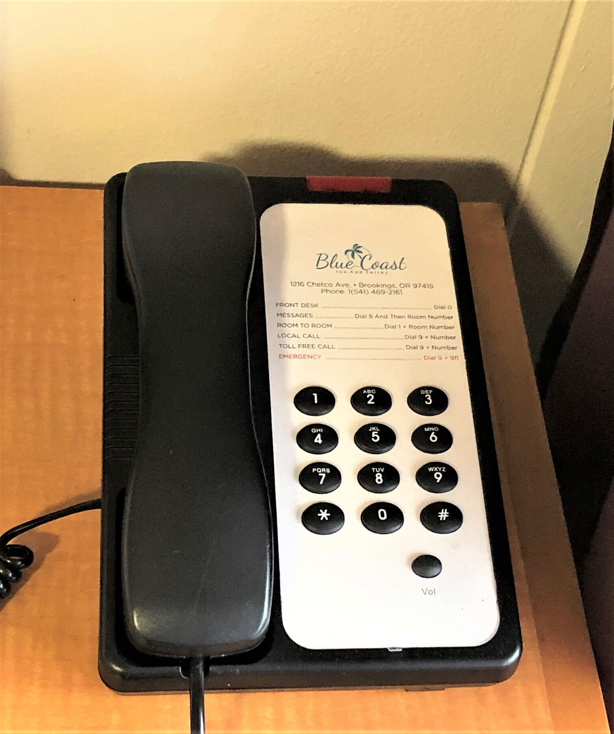 Un téléphone d’hôtel doté d’un clavier et d’un annuaire.