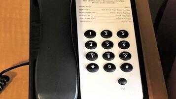 Un téléphone d’hôtel doté d’un clavier et d’un annuaire.