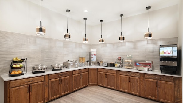 A modern kitchen with wooden cabinets, a white countertop, and pendant lighting. - Best Western Plus Frontier Inn (Cheyenne)