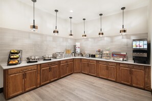 A modern kitchen with wooden cabinets, a white countertop, and pendant lighting. - Best Western Plus Frontier Inn (Cheyenne)