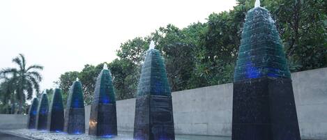 A series of water fountains with a modern design, lined up along a pathway.