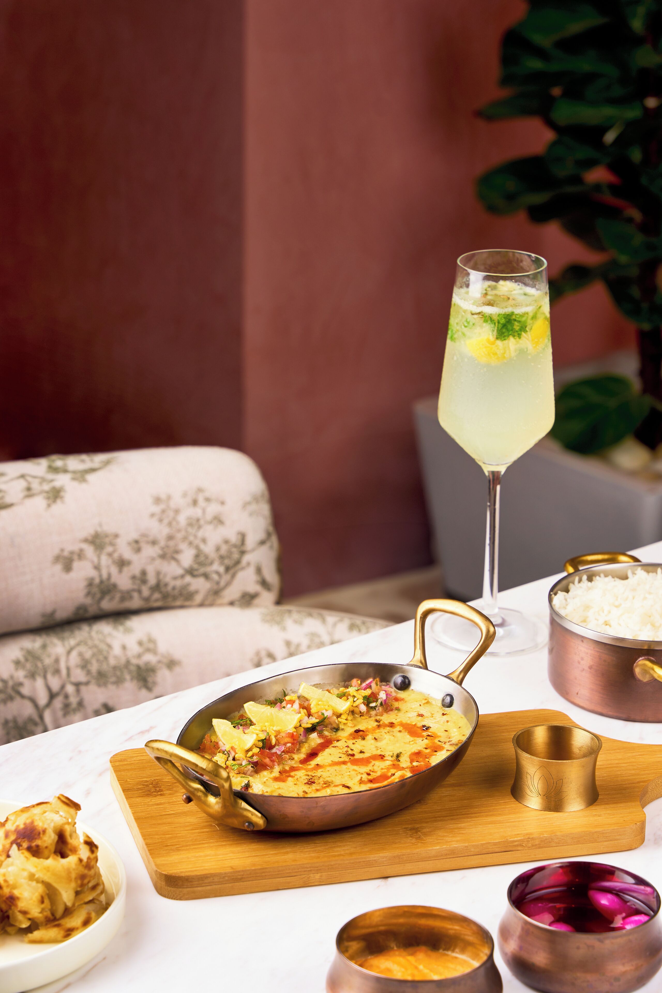 A dining table with a meal, a drink, and traditional serving vessels.