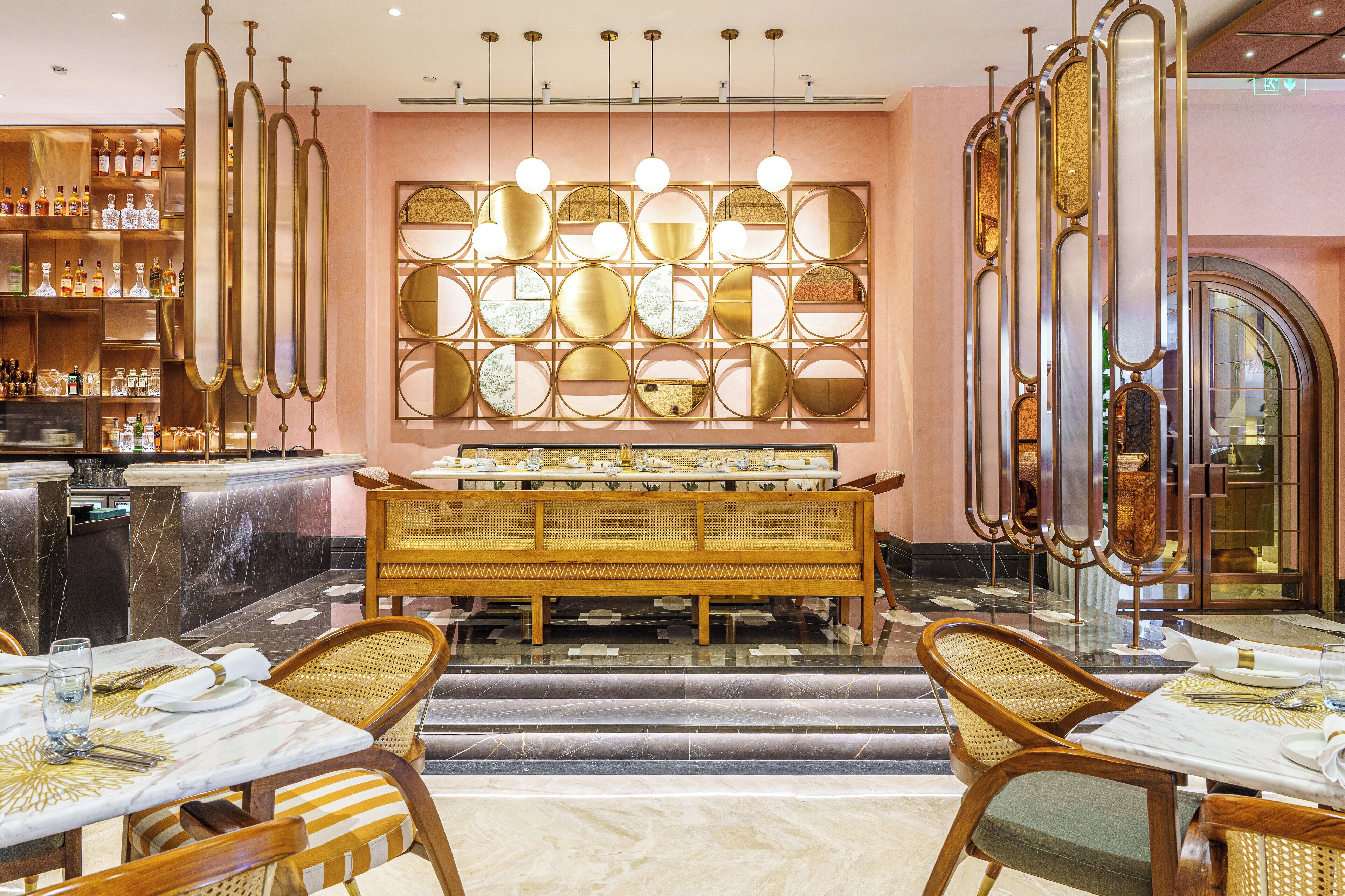 A restaurant with a bar area, a wall of circular mirrors, and a buffet setup.