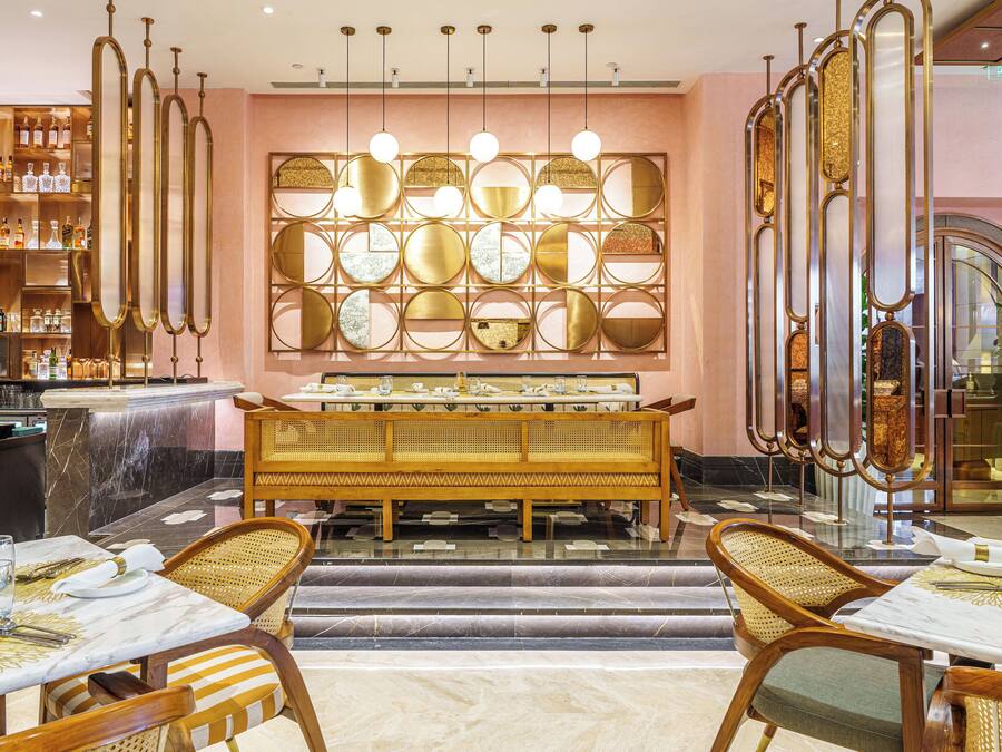A restaurant with a bar area, a wall of circular mirrors, and a buffet setup.