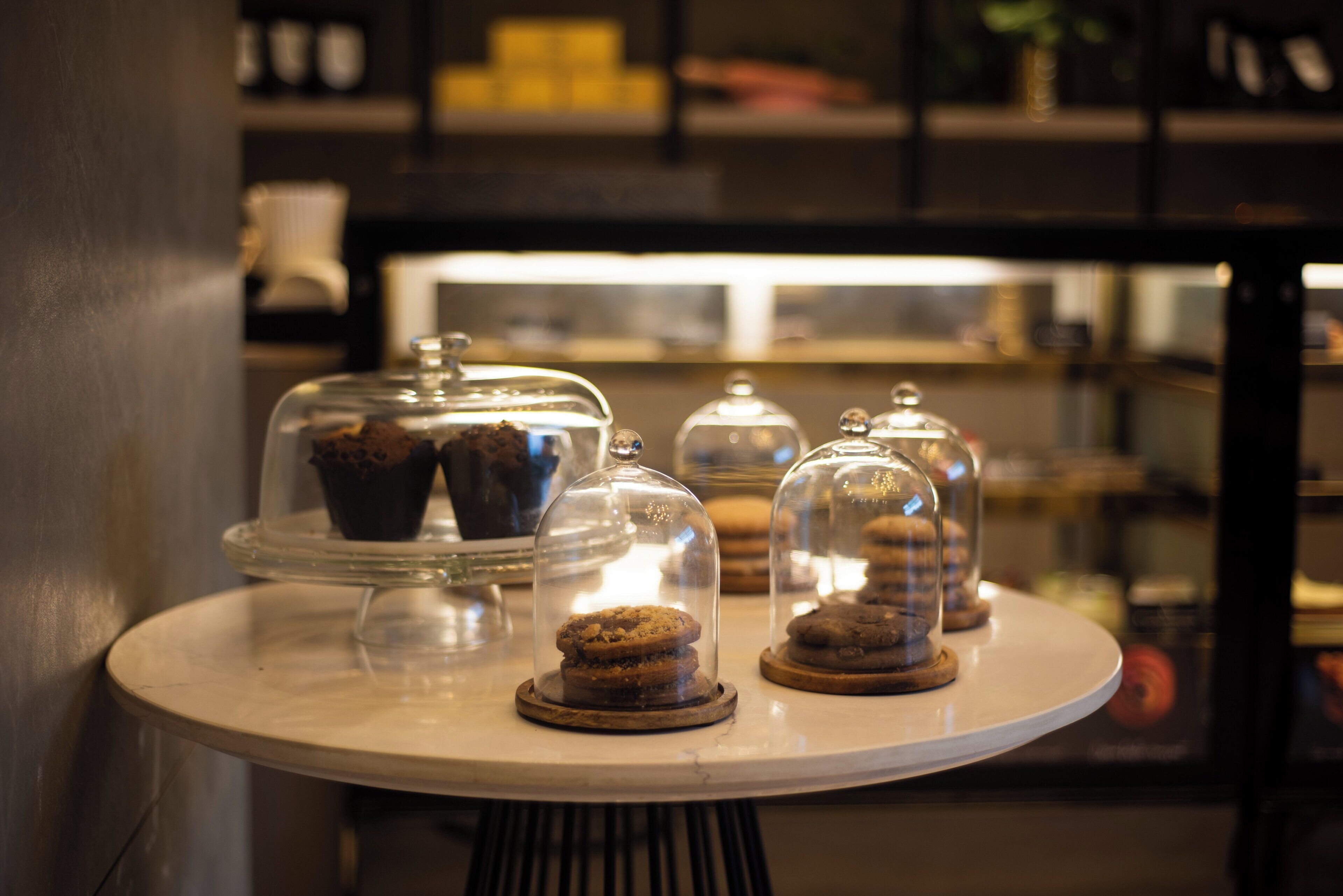 A dessert display with various covered pastries on a table.