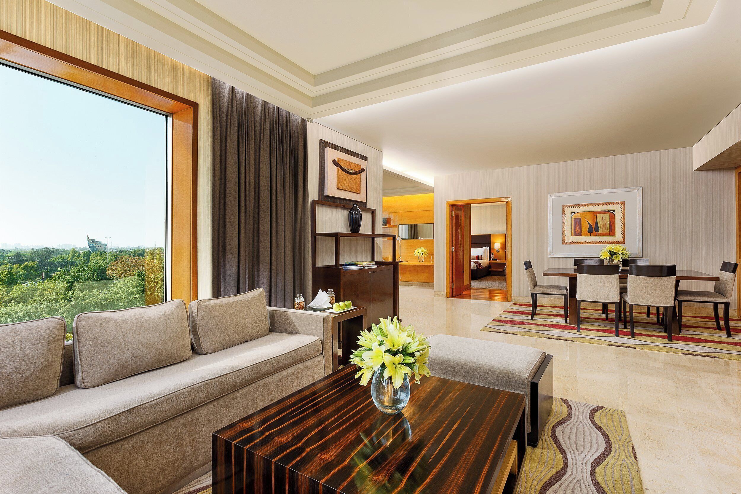 A modern living room with a sofa, a coffee table, and a dining area with a table and chairs.